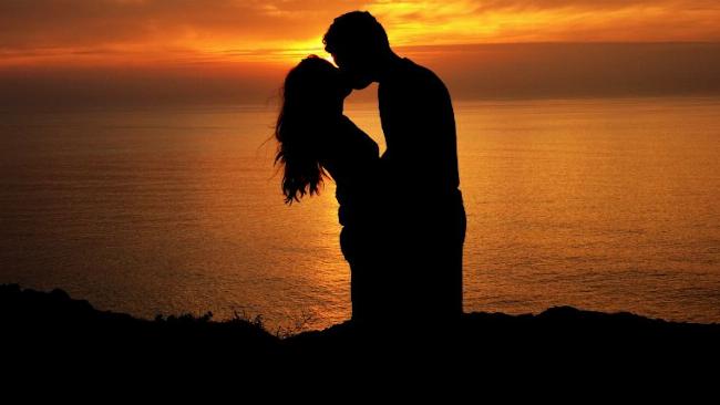 Hình ảnh một cặp đôi đang hôn nhau một cách hạnh phúc, tượng trưng cho lợi ích về cảm xúc và sức khỏe của nụ hôn