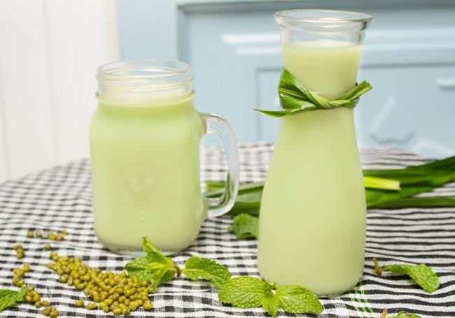 Quá trình nấu sữa đậu nành nguyên xác trên bếp, khuấy đều để tránh cháy khét